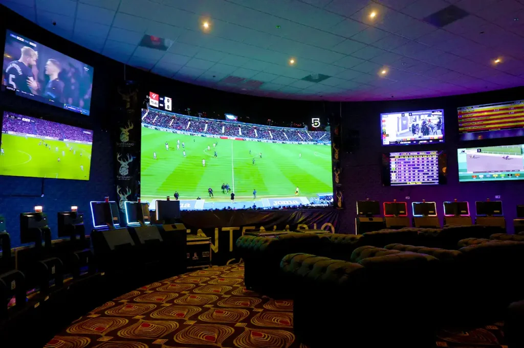 Pantallas gigantes con transmisiones deportivas en vivo en Casino Centenario.
