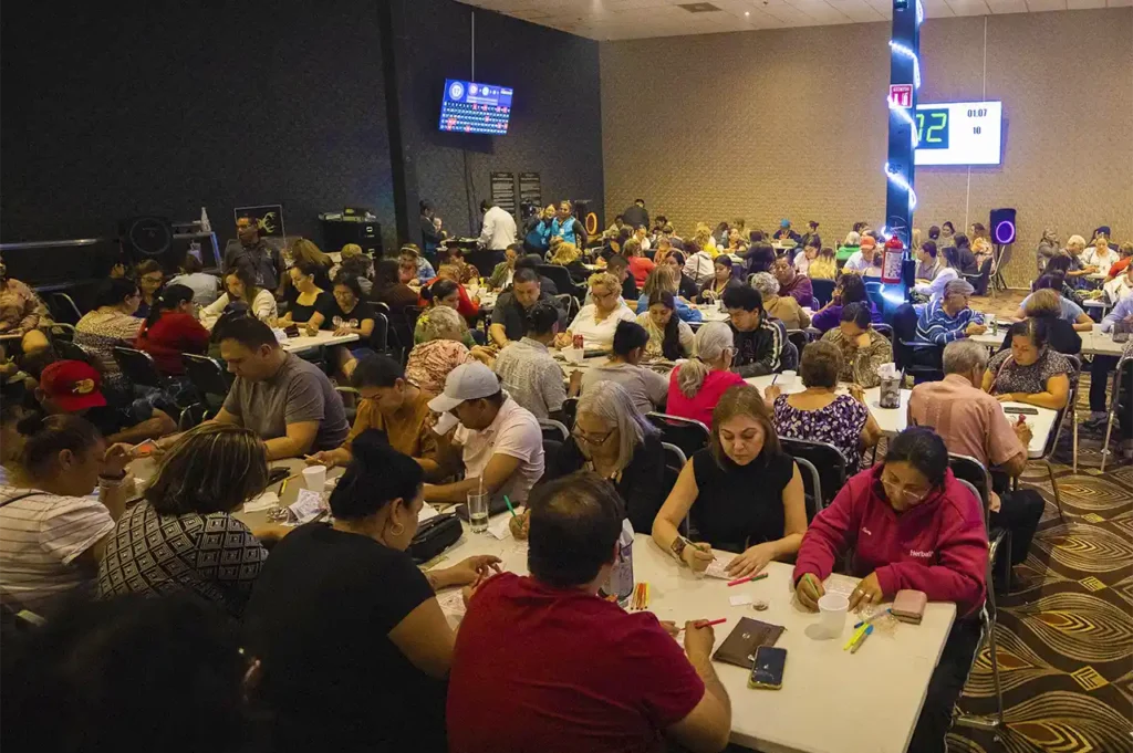 Salón lleno de personas participando en juego de bingo en Casino Centenario.
