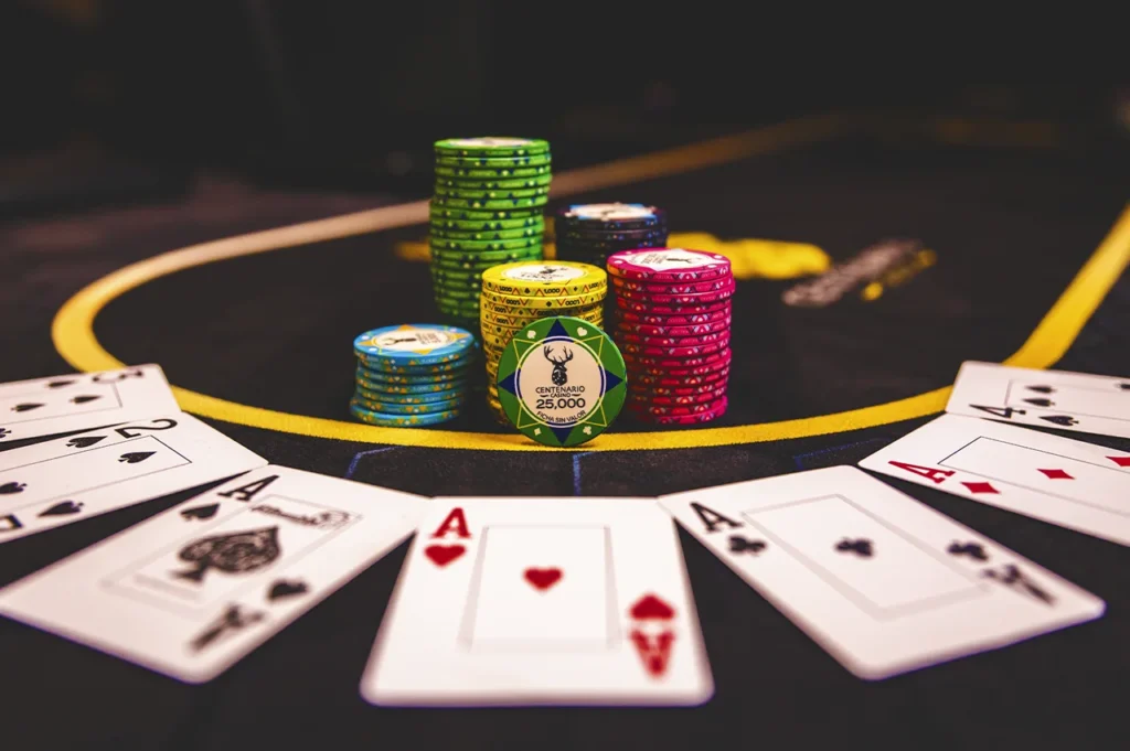 Cartas de póker y fichas de casino sobre mesa de juego en Casino Centenario.